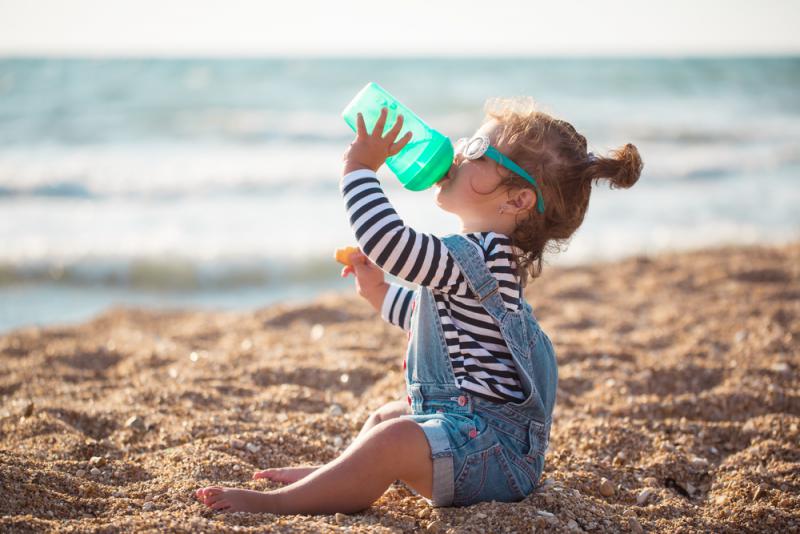 meisje drinkt op strand