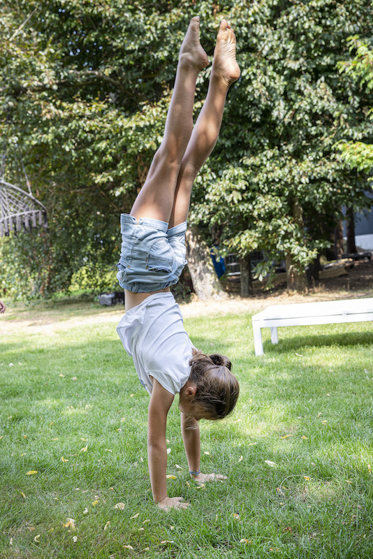 Meisje doet handstand in de tuin