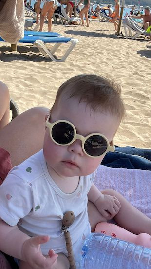 peuter met zonnebril op strand
