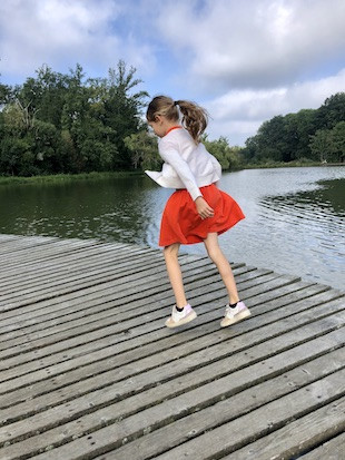 Meisje huppelt op pad naast water