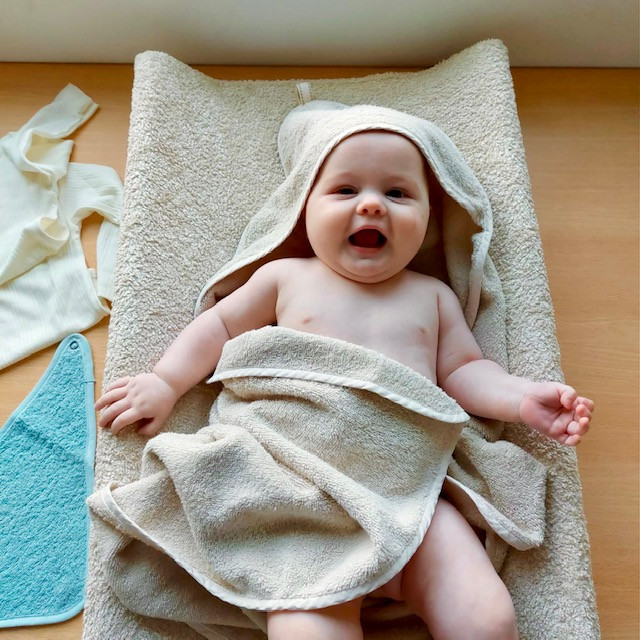 Baby op ververskussen in badcape
