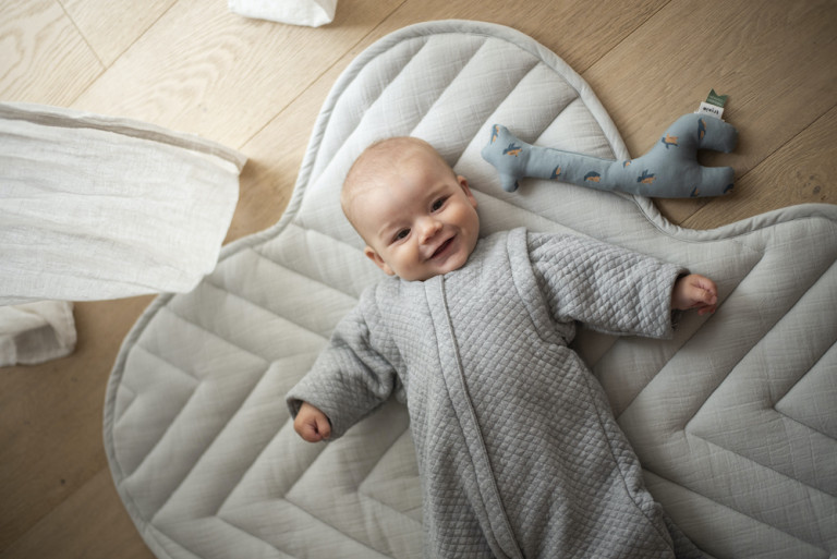 baby op speelmat in slaapzakje