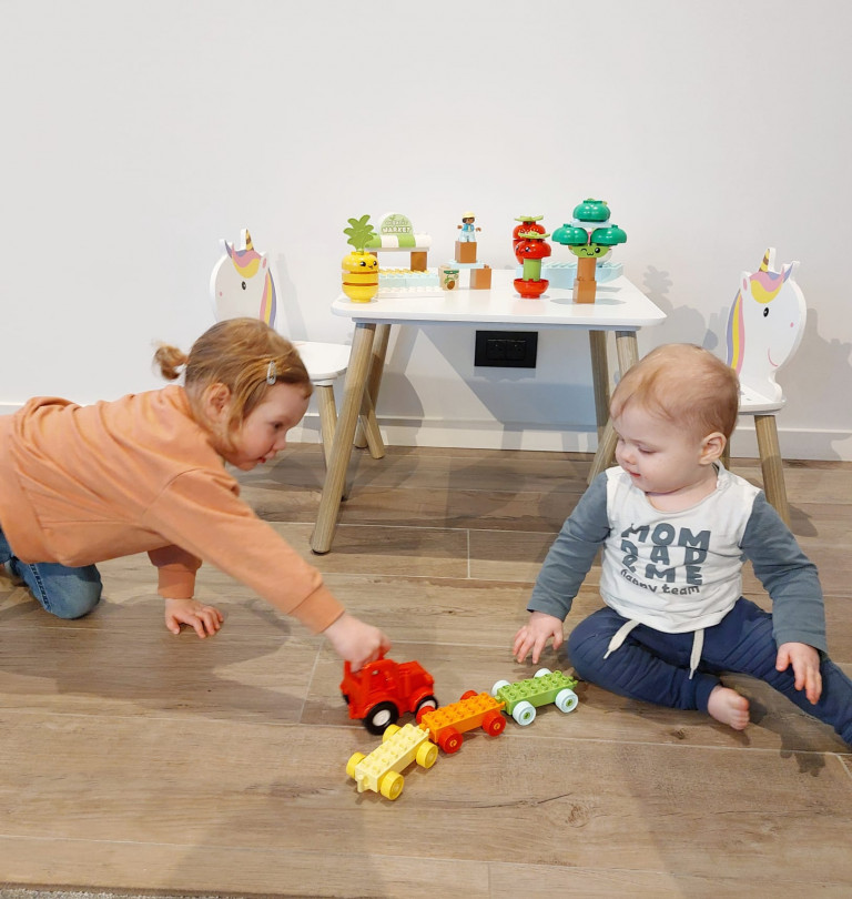 Meisje en baby broer spelen met LEGO DUPLO
