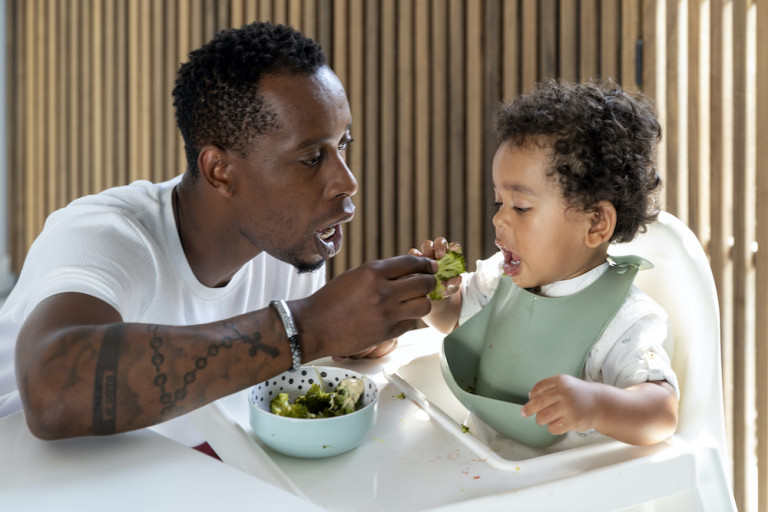 papa geeft peuter eten brocolli