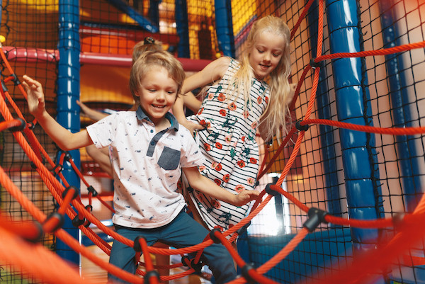 Jongen en meisje spelen in binnenspeeltuin