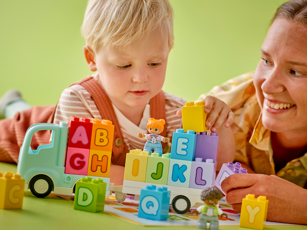 Mama en peuter spelen met LEGO DUPLO Alfabetvrachtwagen