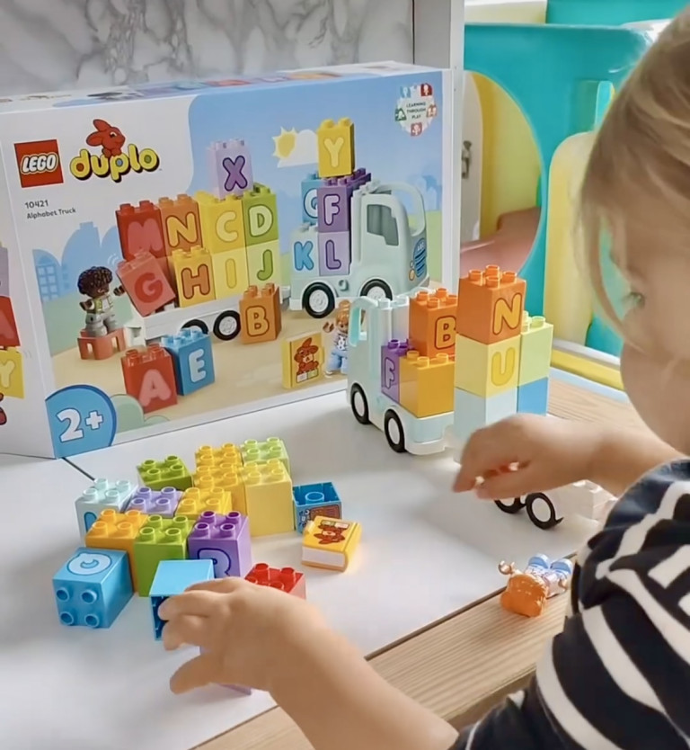 Kleuter speelt met LEGO DUPLO Alfabetvrachtwagen