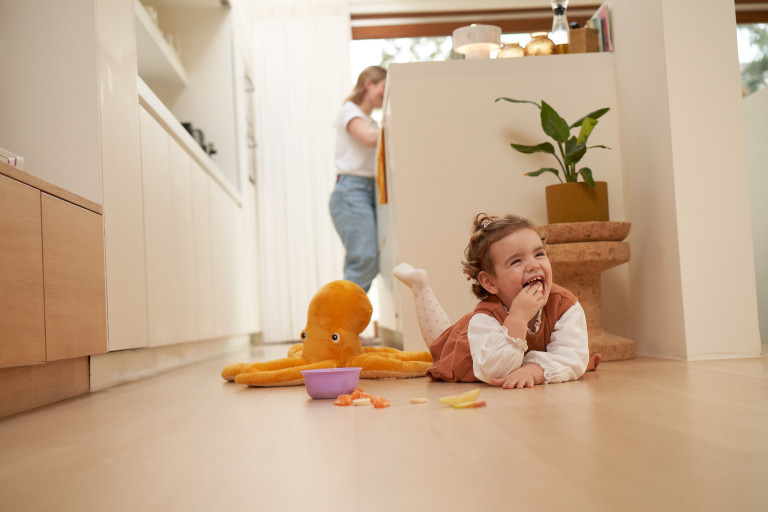 Kindje ligt op de grond en eet fruit