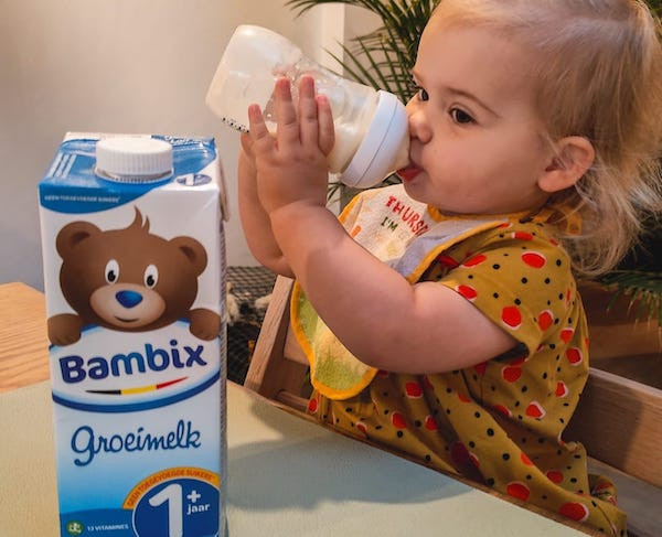 Peuter drinkt groeimelk uit een flesje