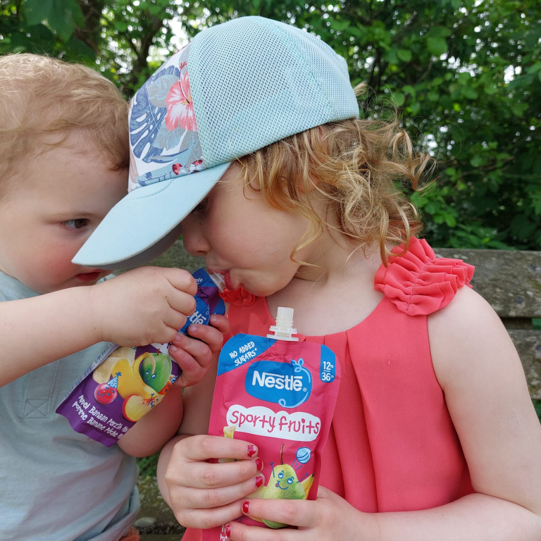 Peuter en kleuter met vieruurtje fruitknijpzakje