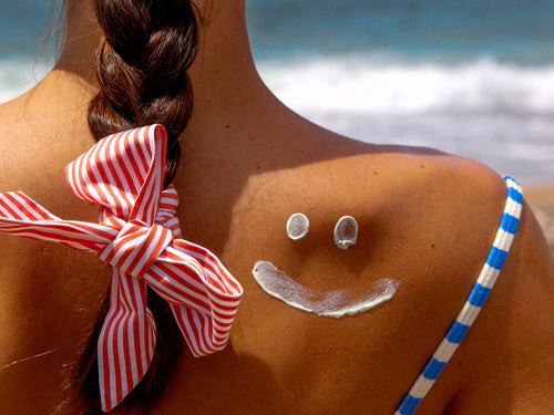 zonnecrème smiley op schouder