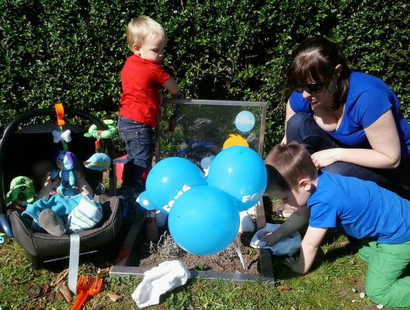 mama met drie kinderen aan grafje kind