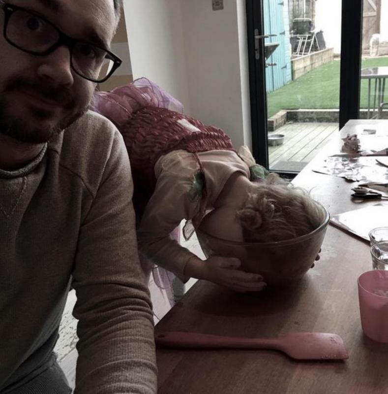 papa met dochter die hoofd in slakom heeft gelegd