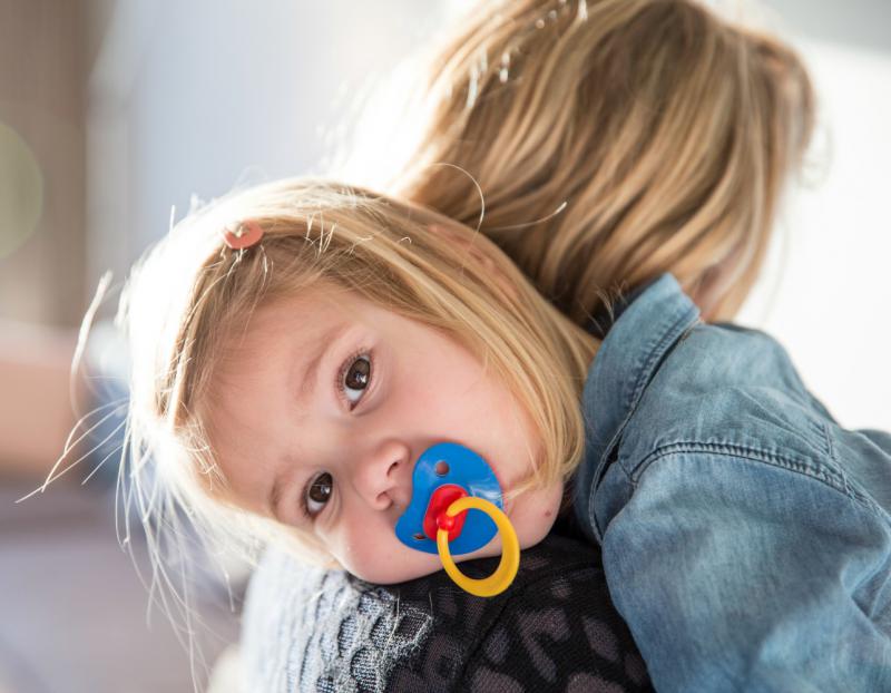 Kindje ligt op de schouder van de mama