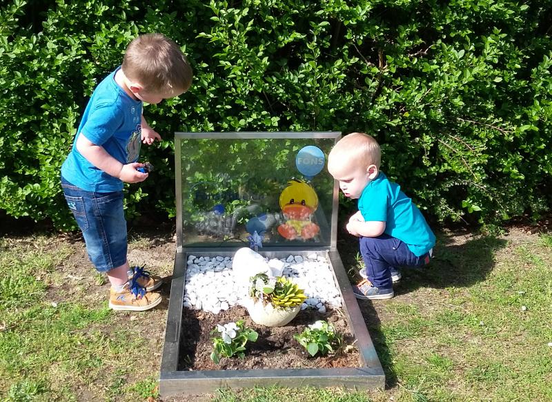 twee jongens aan grafje baby