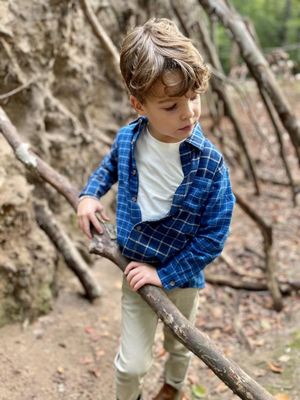 Jongetje speelt met tak in het bos