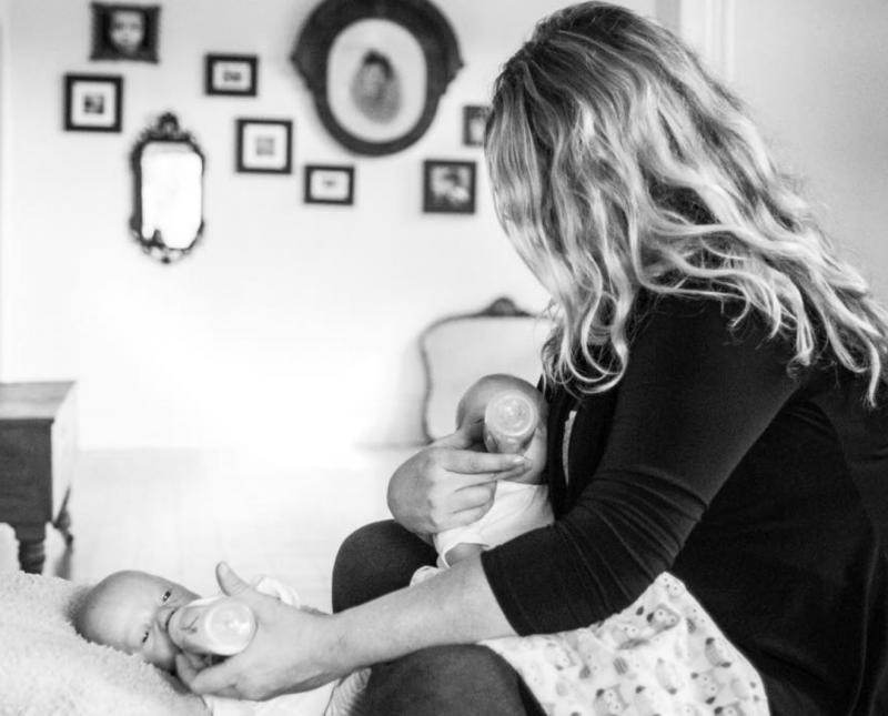 mama geeft flesje aan tweeling