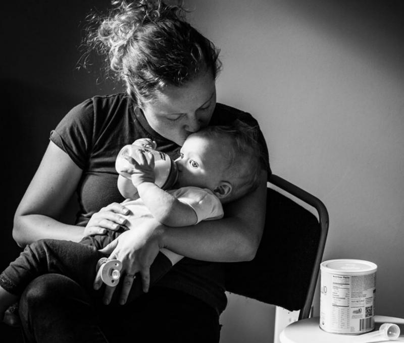 mama geeft flesje aan baby