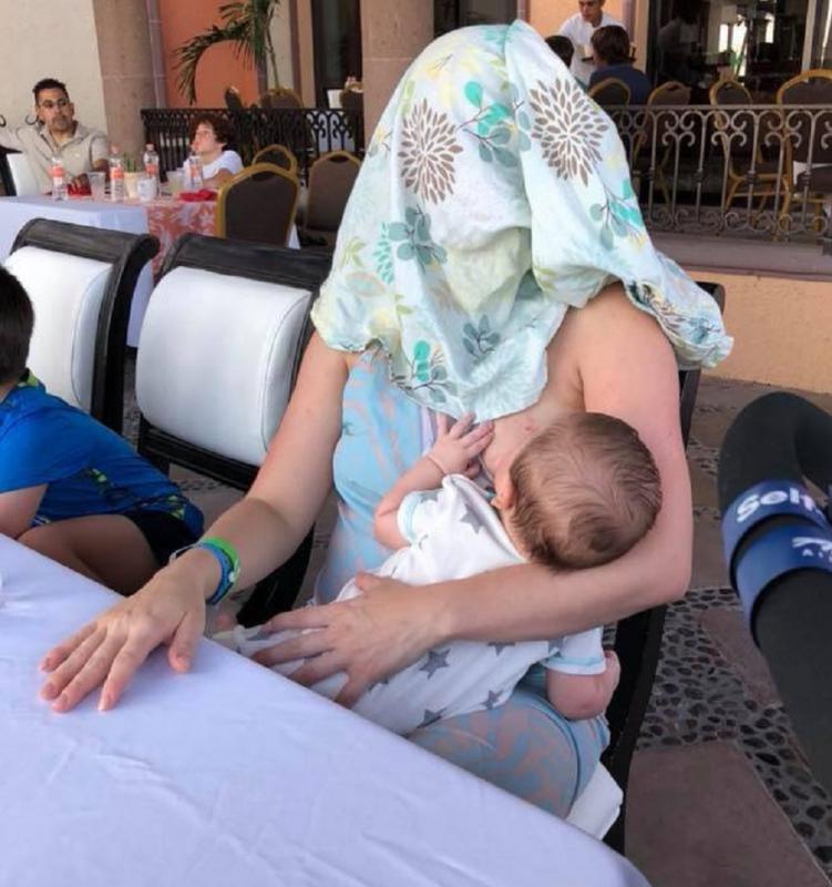 mama geeft borstvoeding met doek over hoofd