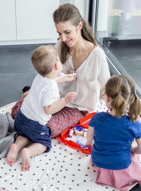 mama met twee kindjes die dokter spelen