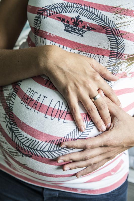 mama met handen rond zwangere buik