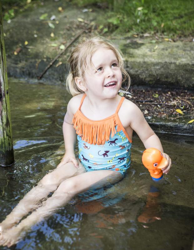klein meisje met waterpistool in water