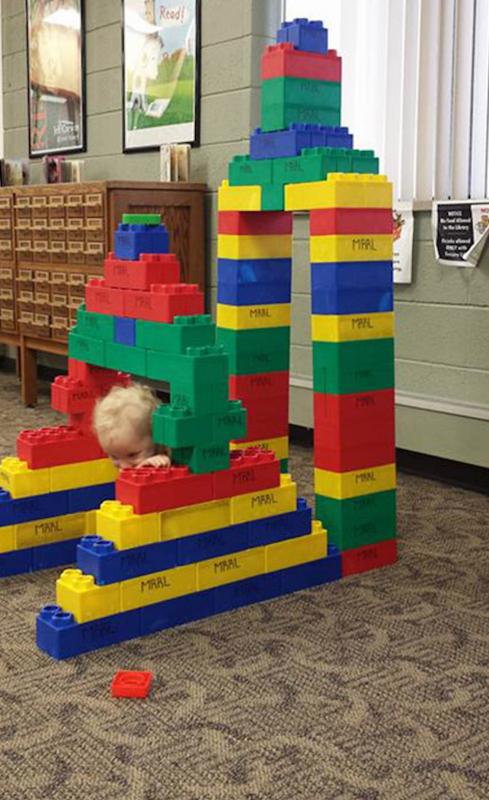 kind verstopt achter lego-toren