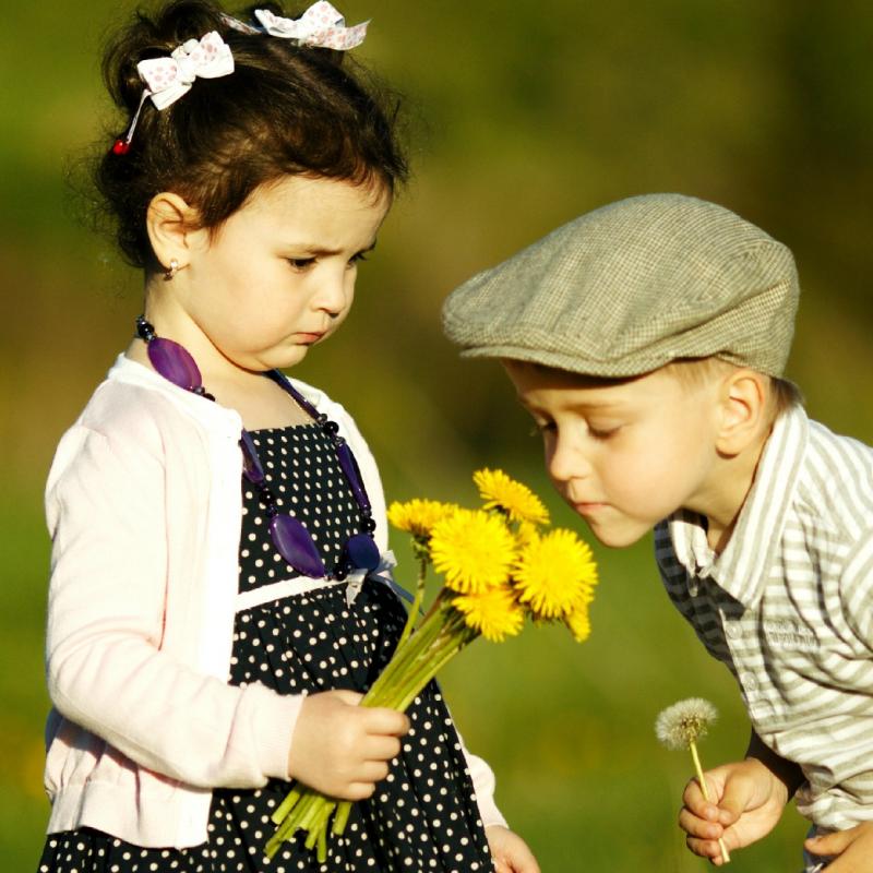 jongen en meisje ruiken aan een bloem