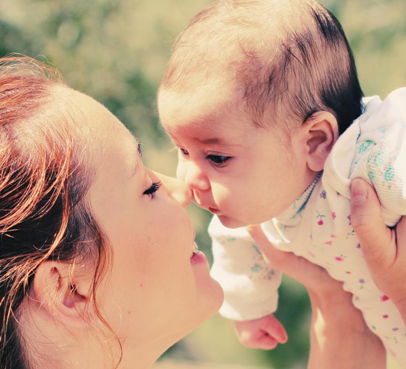 mama geeft kus aan baby 