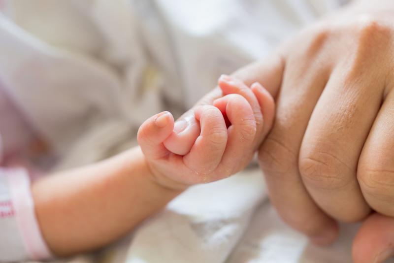 babyhandje knijpt in vinger mama