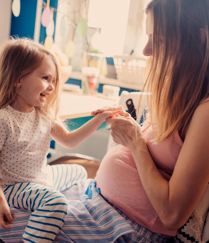 meisje met zwangere mama in keuken